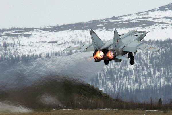Fighter on take-off against the background of a snowy mountain