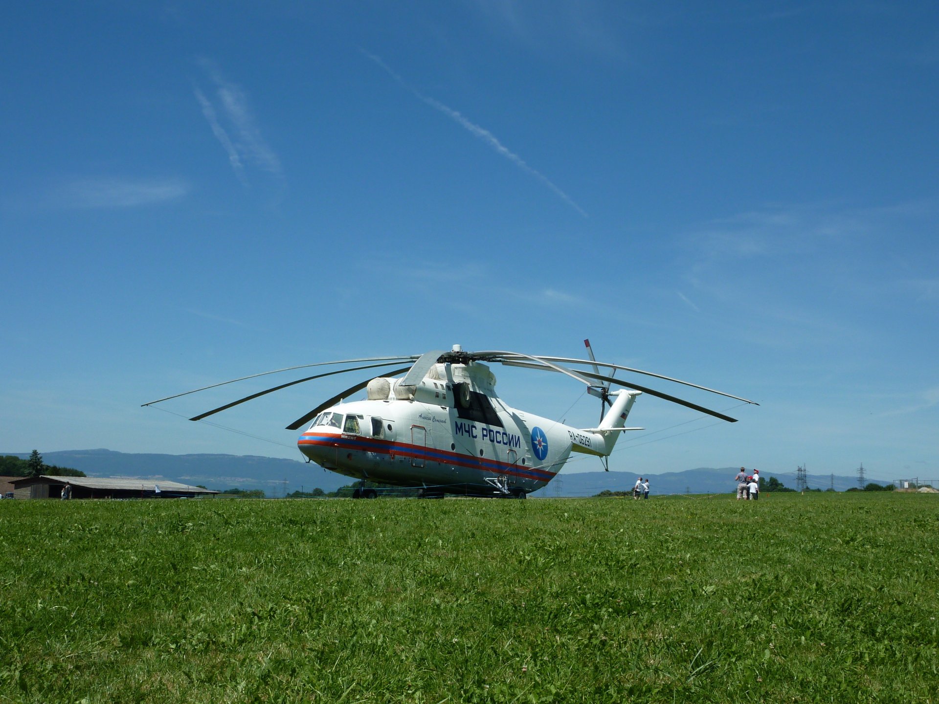 mi-26 katastrophenschutzministerium russland menschen haus berge wiese gras wolken himmel haus