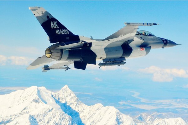 Flying over the snowy mountains of a military aircraft