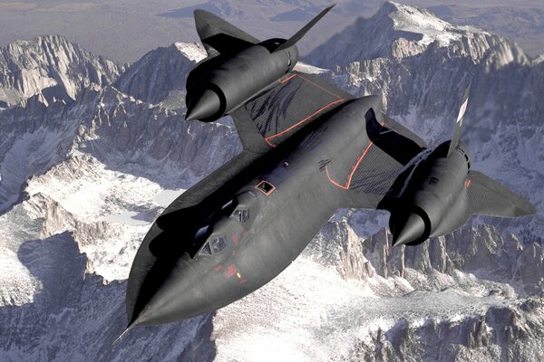 A huge black fighter jet in the sky above the snowy peaks of the mountains
