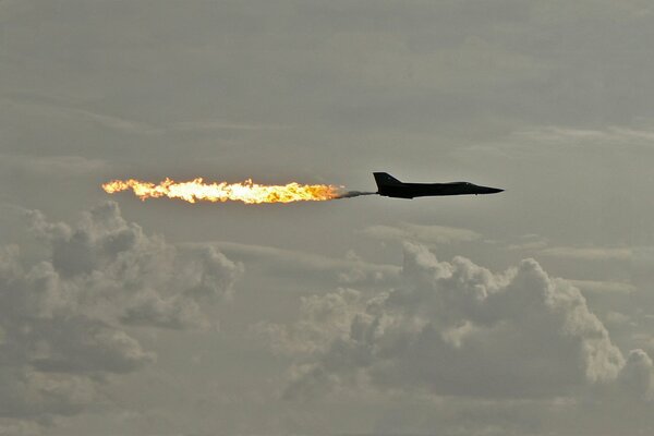 The tail of the flame of the plane in the graying sky