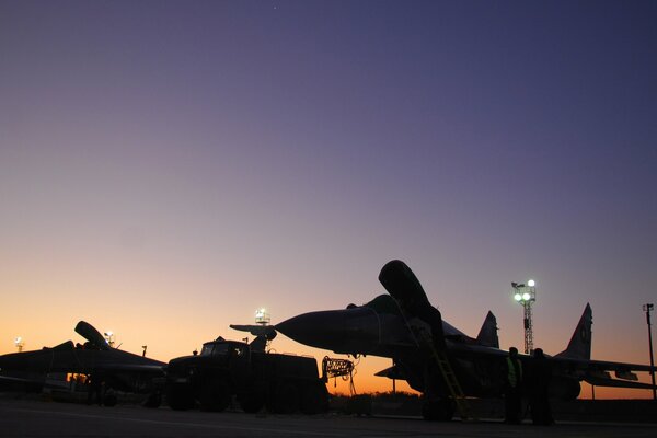 Cazas MIG-29 de pie en el aeródromo al atardecer