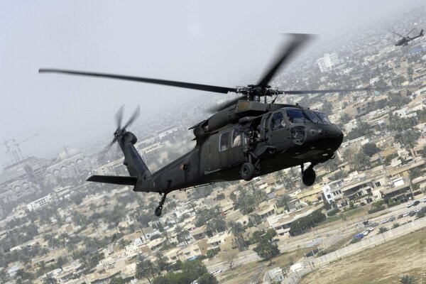 US UH-60 helicopter flying over the city