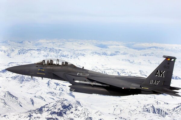 Avión de combate en vuelo de afeitar sobre montañas nevadas