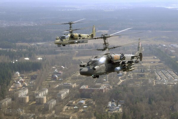 Two ka-52 helicopters in the sky over the city