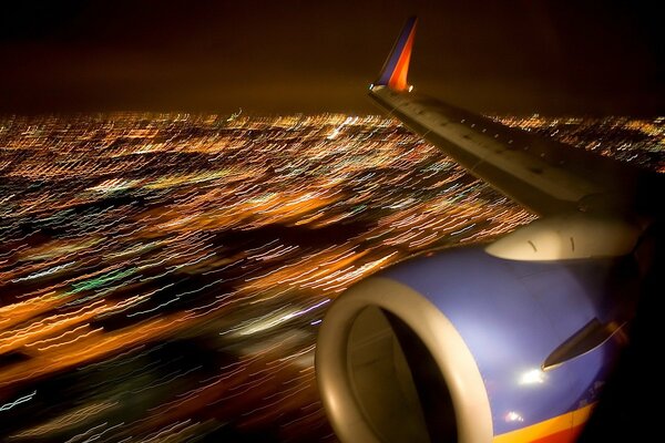 Flugzeugflügel in der Nachtstadt