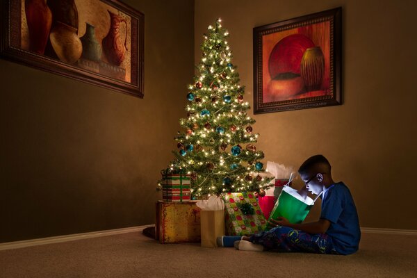 Ragazzo con regali all albero di Natale