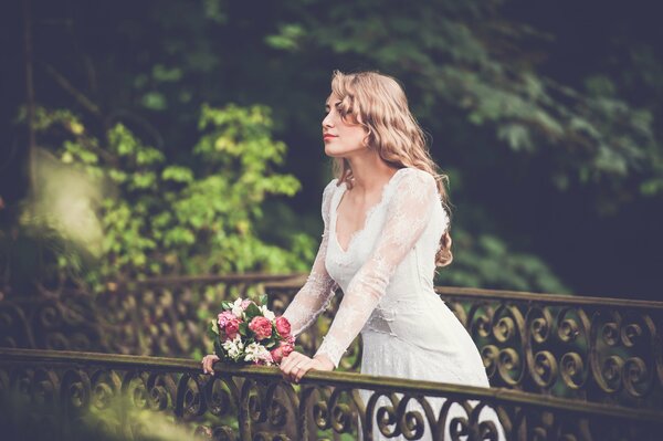 The bride is waiting for the groom on the bridge