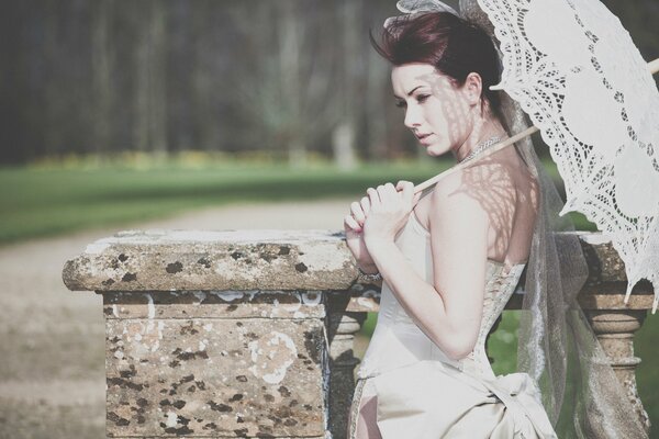 Beautiful bride under a white lace umbrella