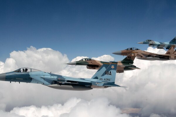 Formación de aviones sobre nubes blancas