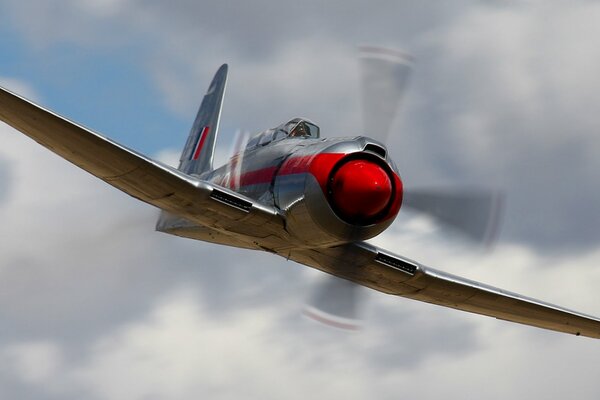 A plane flying in the clouds with a propeller