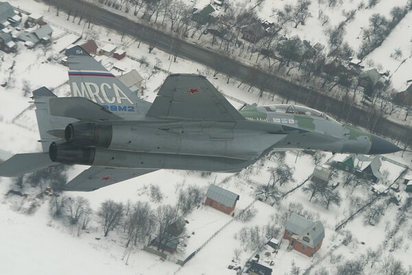 MIG fighter flies over houses