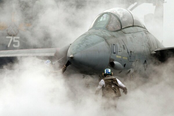 Hombre en el humo frente a un portaaviones de combate