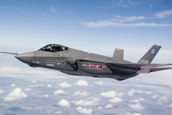 An f-35 fighter jet in flight against the background of a cloud