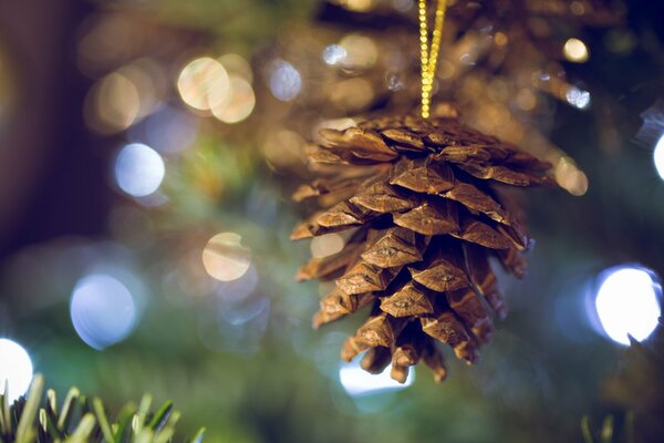 Une pomme de pin pèse sur un arbre de Noël pour les vacances de Noël