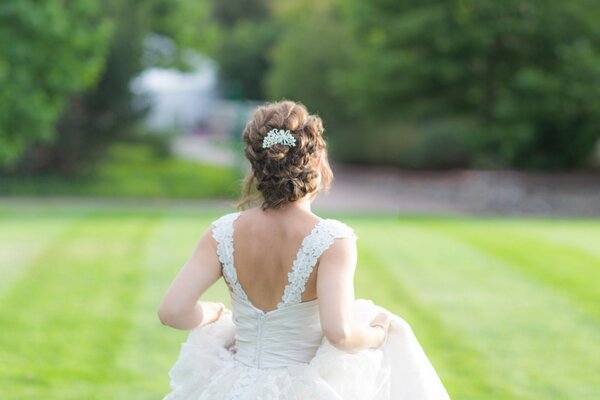 Девушка в свадебном платье на лужайке