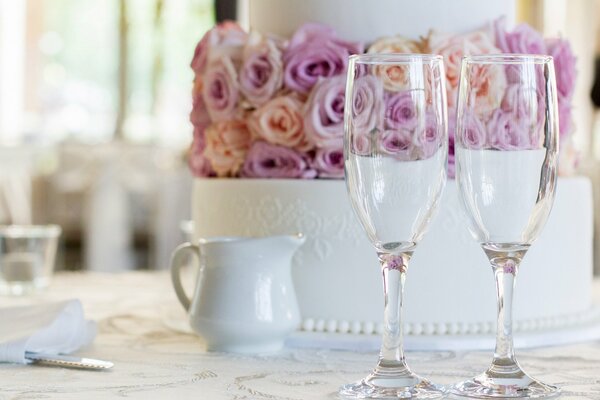 Pastel de bodas con rosas y dos copas de vino