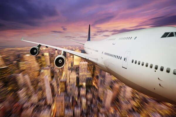 Vuelo de avión sobre la ciudad al atardecer