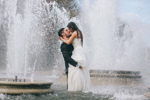 La sposa e lo sposo nella fontana. La gioia del momento