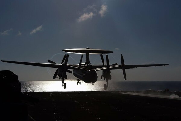 Naval aircraft carrier and aircraft at sunset