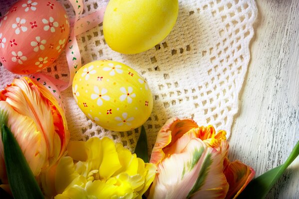 Яркие пасхальные яйца в окружении цветов