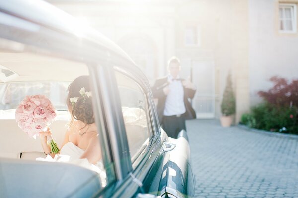 Bride with a bouquet in the car