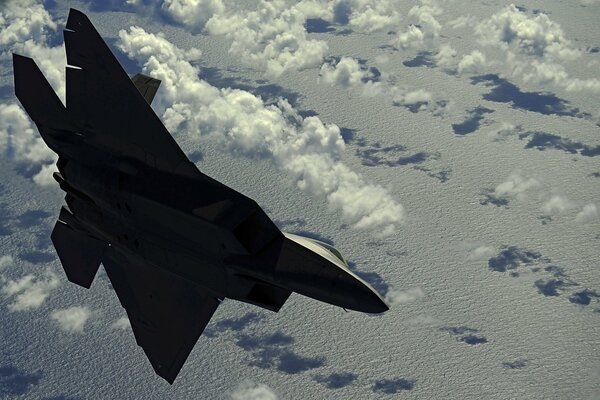 A fighter flying high above the clouds