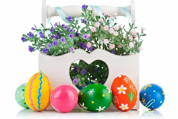 Colorful bright Easter eggs near pots with flowers