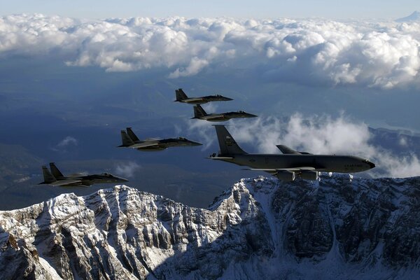 Planes fly over the mountains in a haze of clouds