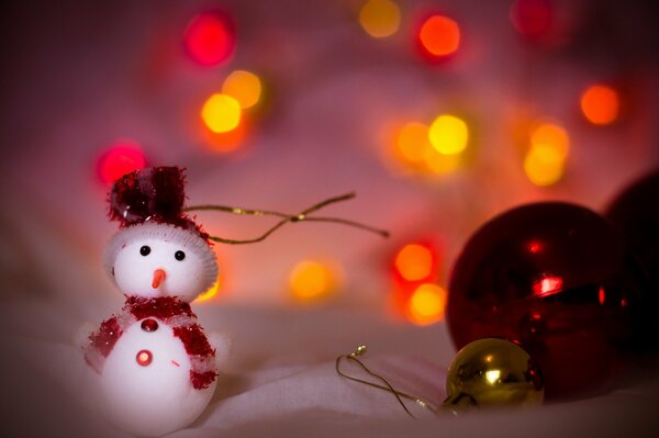 A toy snowman next to red balls