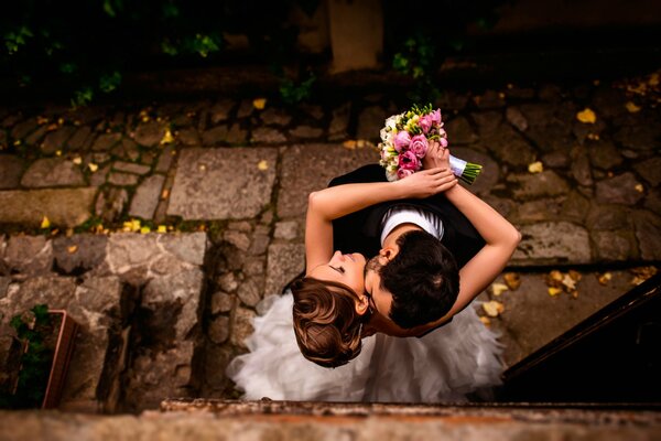 Sesión de fotos de la novia y el novio con un ramo