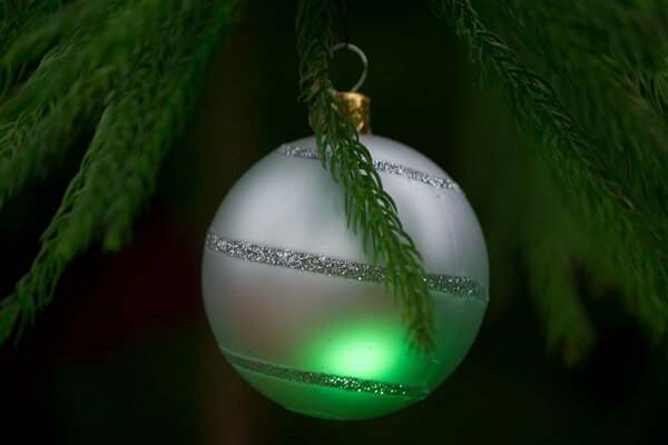 Silbernes Weihnachtsbaum-Spielzeug auf dem Hintergrund des Weihnachtsbaumes