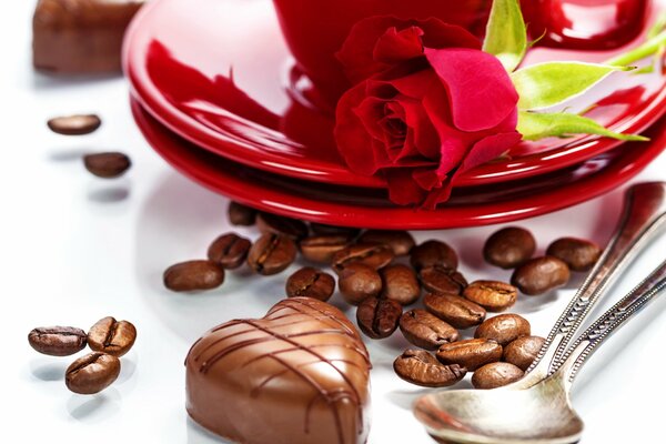 Chocolate heart next to a red rose on a red plate