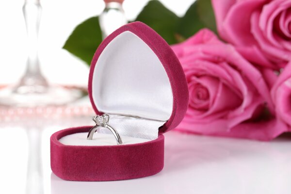 A ring in a pink velvet box. Pink roses. Love