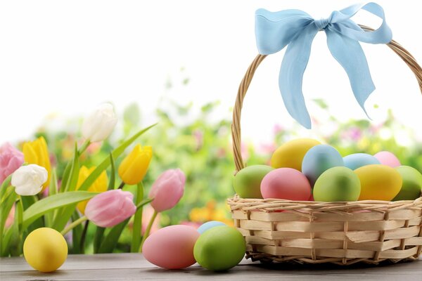 A basket with a blue bow and Easter eggs