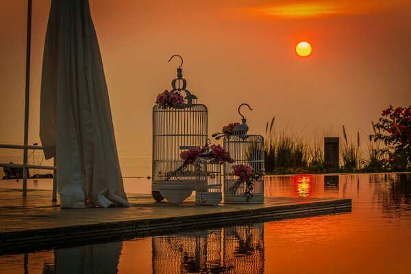 Weiße Käfige für Vögel vor Sonnenuntergang Hintergrund