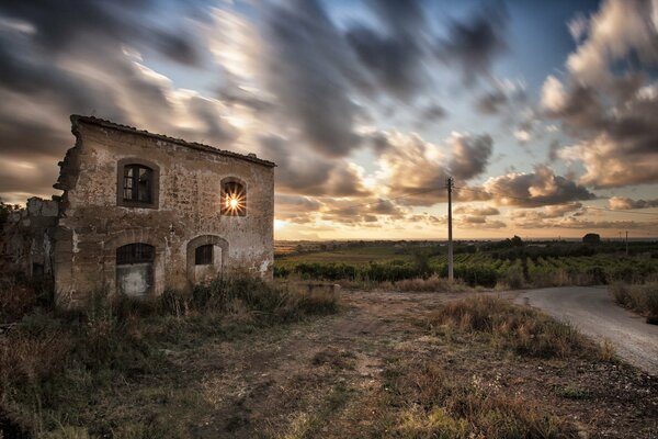 Casa in un campo al tramonto