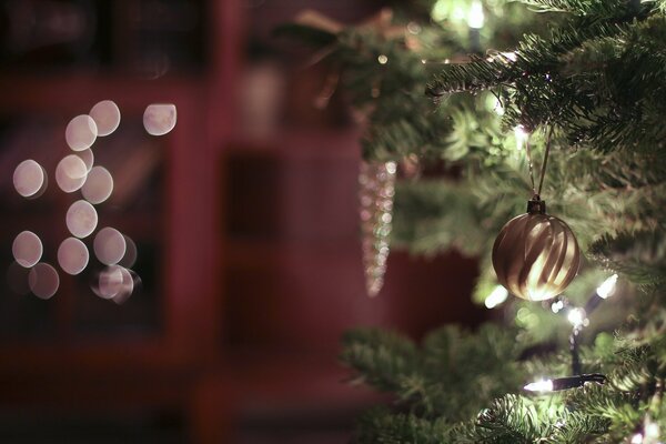 Ein Spielzeugzapfen auf einem Ast eines Weihnachtsbaumes