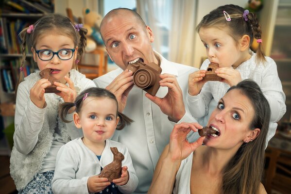 The family on the feast of Holy Easter all eat festive chocolate together