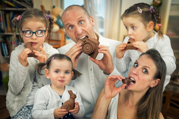 Famille à la fête de la Sainte Pâques tous ensemble manger du chocolat festif