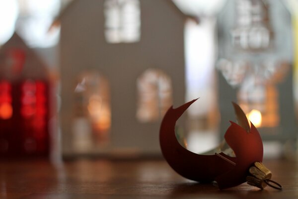 A broken Christmas tree toy on the background of a paper house