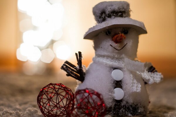 Pupazzo di neve in un cappello e con due palle decorative rosse