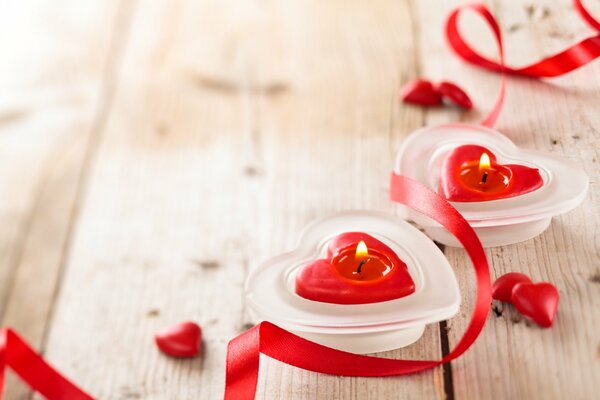 Lit candles in the form of red hearts