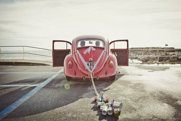 Ein altes Auto, an das Aluminiumdosen gebunden sind