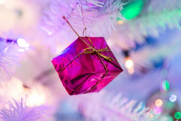 Caja rosa en el árbol de Navidad con luces