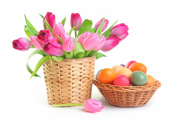 Ein Korb mit Tulpen und ein Korb mit Ostereiern