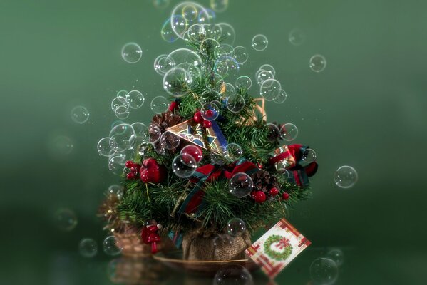 A small Christmas tree with toys on a green background