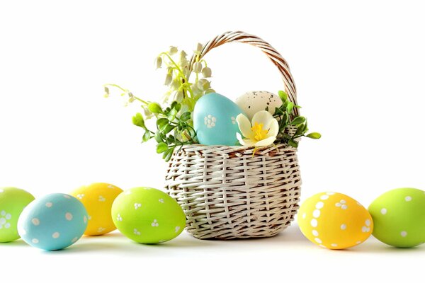 Basket with colorful eggs and flowers