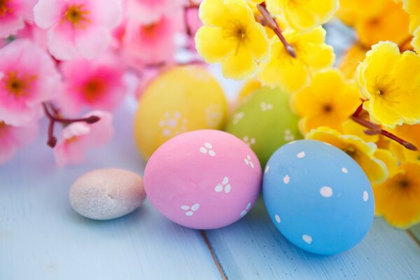 Easter eggs with patterns on a background of yellow and pink flowers