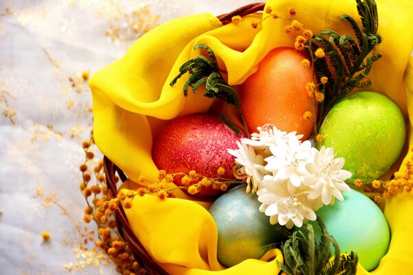 Osterkorb mit schönen Eiern und Blumen